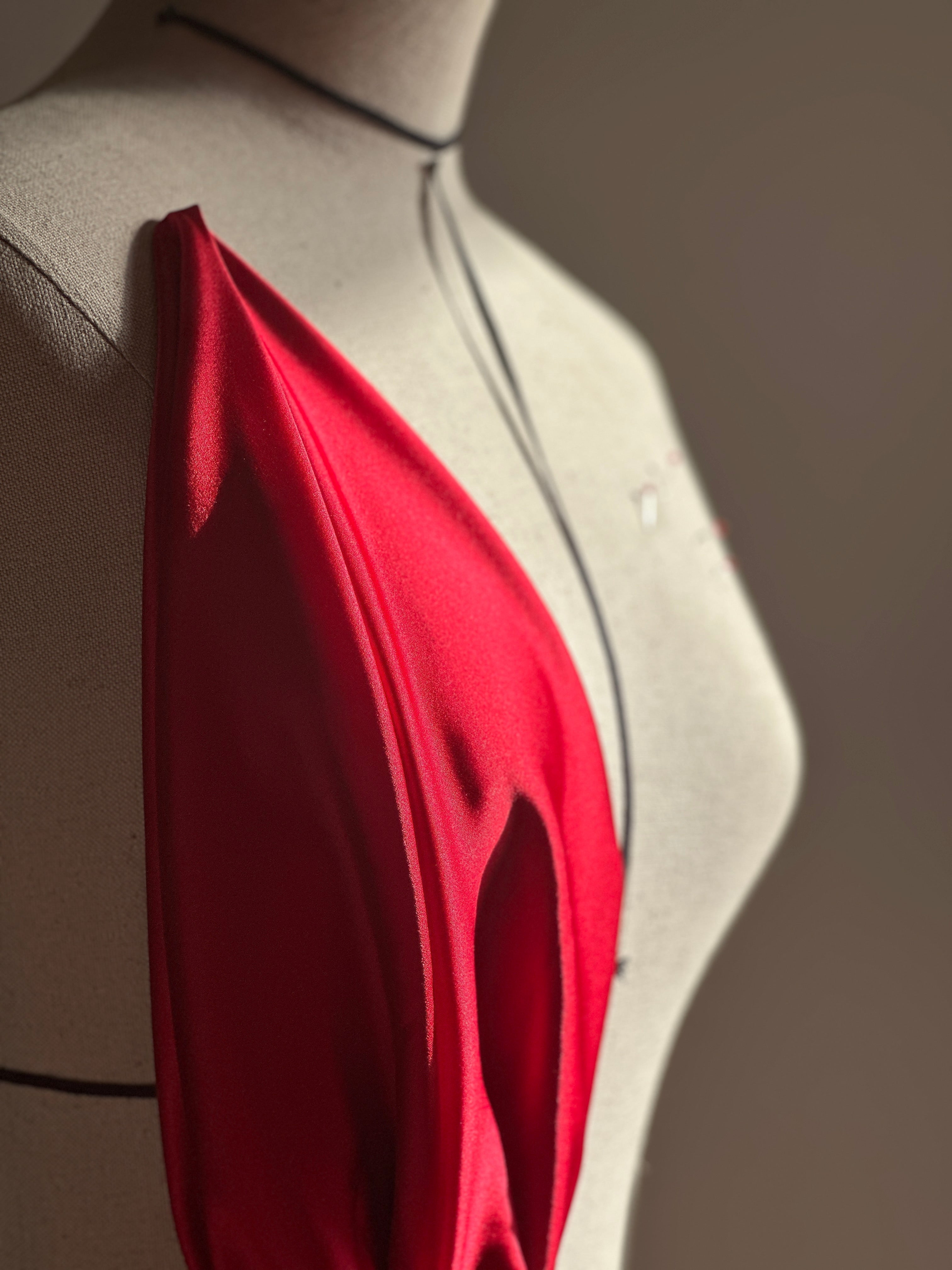 vue côté soie rouge accroché sur mannequin de couture